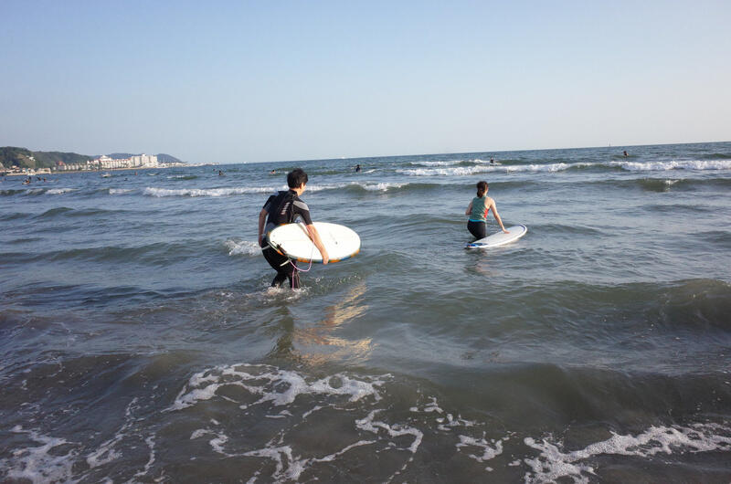 Two surfers heading out at Kamakura Beach