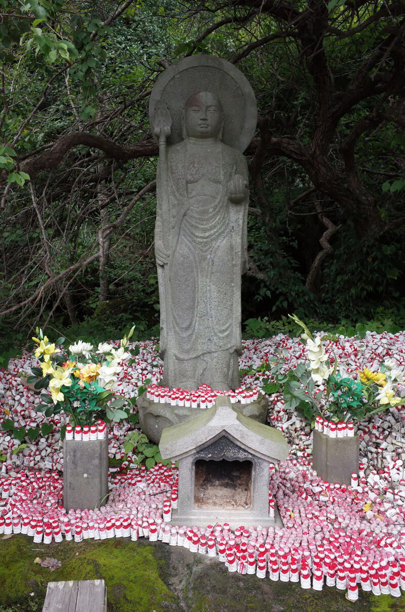 A Buddha statue surrounded by smaller Buddha figurines