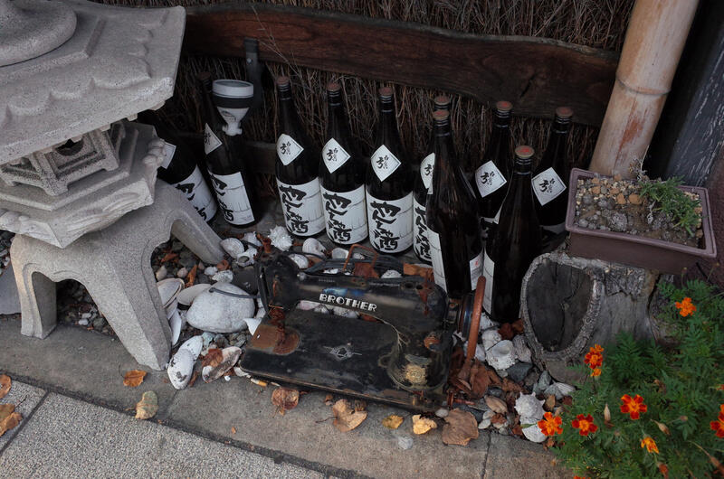 An old Brother sewing maschine surrounded by glass bottles