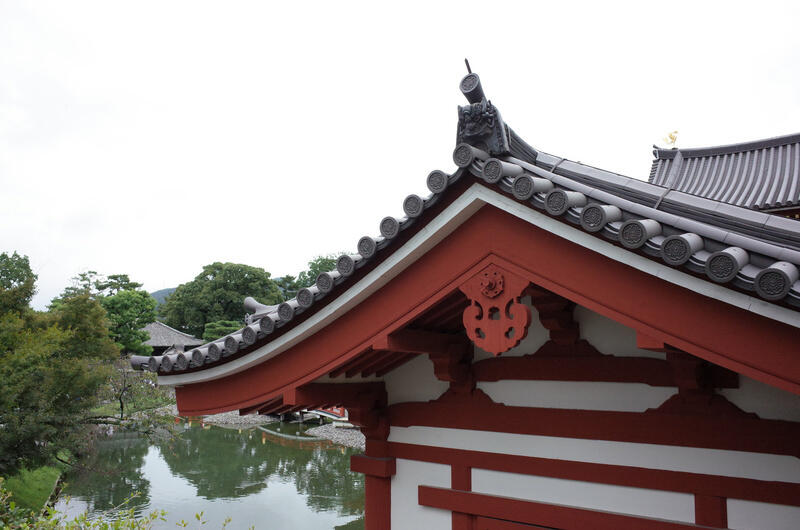 The roof of a temple building with a lake in the background