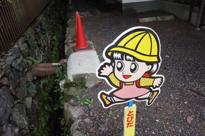 A sign featuring a cartoon drawing of a girl with a yellow hat